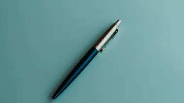 Stylo posé sur un formulaire papier à cocher, sur une table en bois