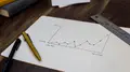 Graphique circulaire imprimé sur une feuille, posé à côté d’une tasse de café